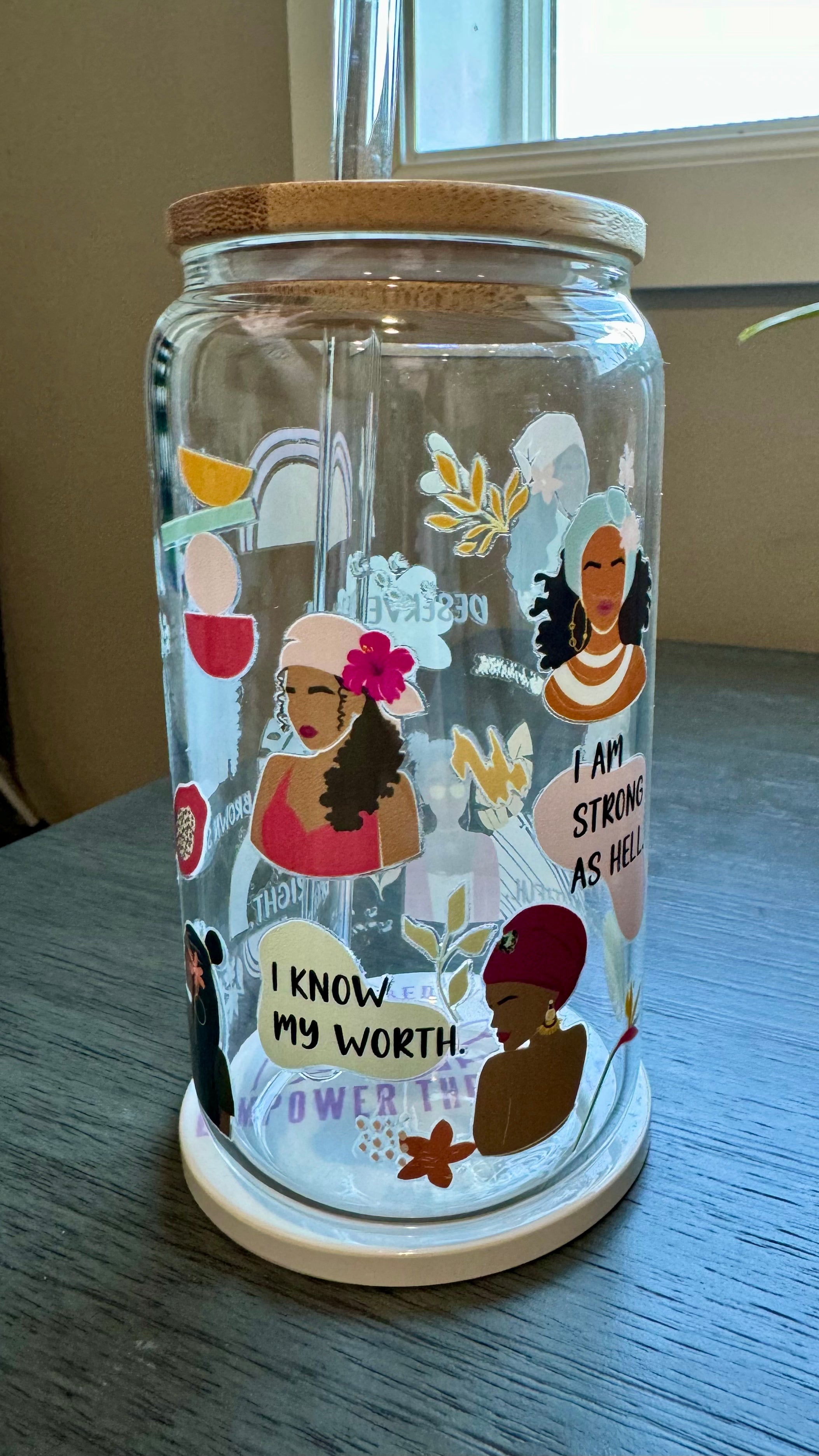 Sip in style with our "I am..." Glass Tumbler. This 16 ounce tumbler features a durable UV DTF transfer, showcasing empowering statements such as "strong as hell" and "beautiful brown sugar." Show off your confidence while staying hydrated.