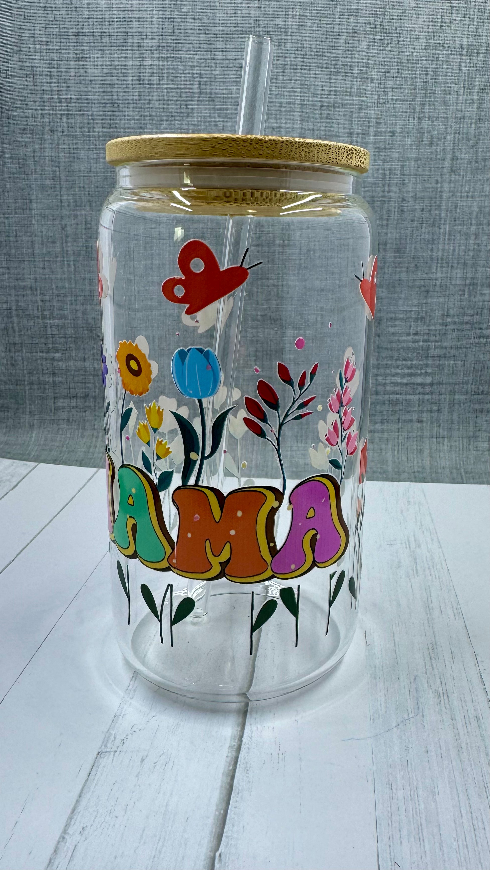 The MAMA Glass Tumbler features a beautiful UV DTF transfer design of flowers and butterflies. With a 16 ounce capacity, it is perfect for your favorite cold beverages. Stay hydrated and in style with this elegant and durable tumbler.