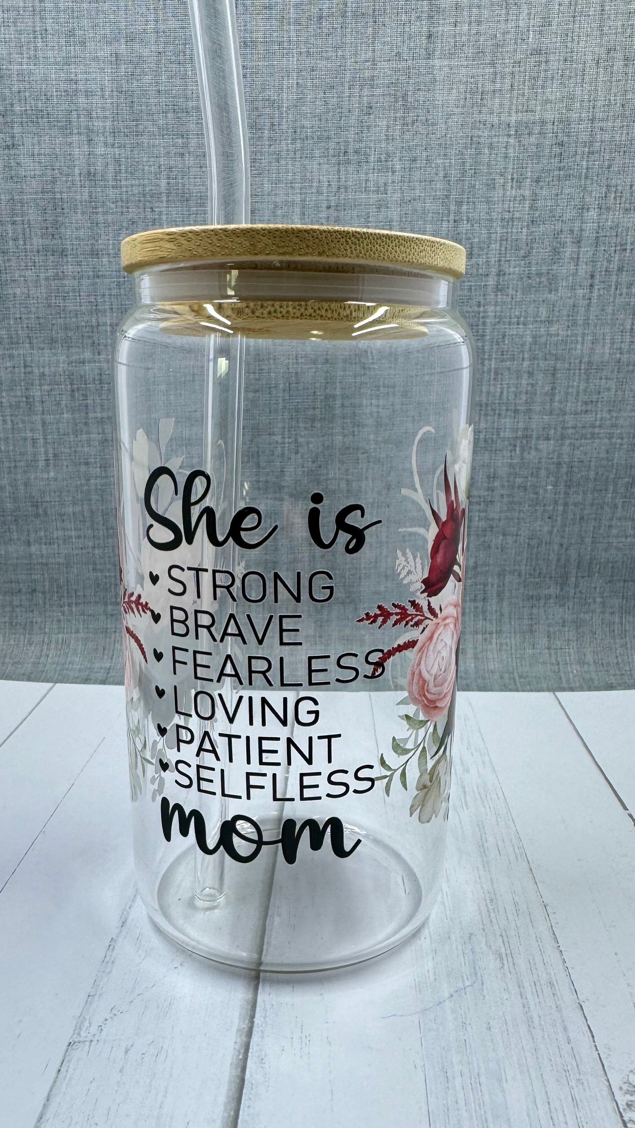 Elevate your gift-giving game with our She is...mom Glass Tumbler. Crafted with a 16 ounce capacity, this tumbler is adorned with beautiful red and pink roses. The UV DTF transfer showcases the phrase "she is strong brave fearless loving patient selfless mom", making it the perfect way to show appreciation for the special mom in your life.