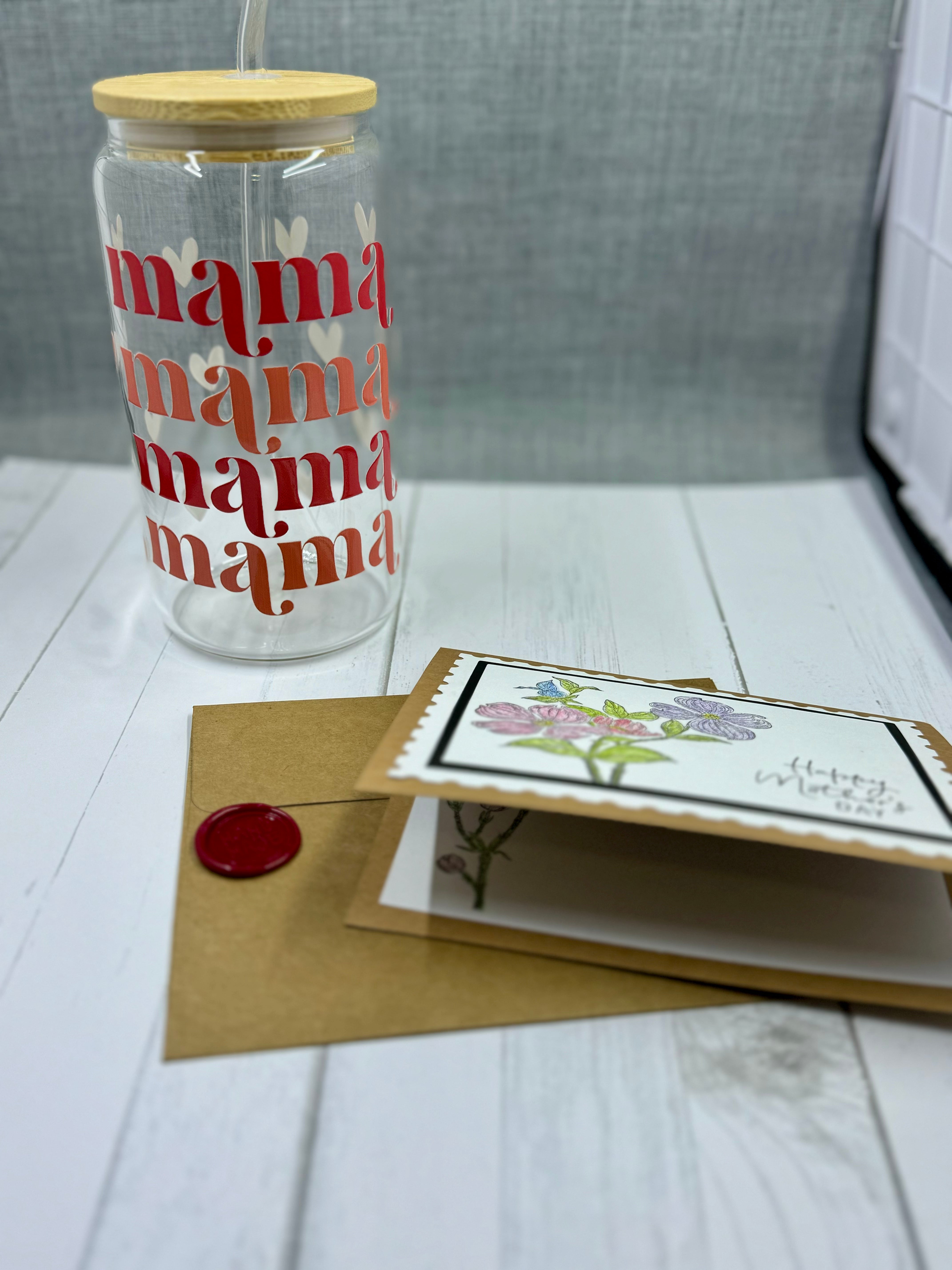 Celebrate Mother's Day with our MAMA Glass Tumbler Set. This 16oz tumbler features a unique UV DTF transfer, perfect for moms who appreciate quality and style. The set also includes a beautifully designed Mother's Day card with a wax seal for an extra personal touch. Show your love and appreciation with this thoughtful gift set.