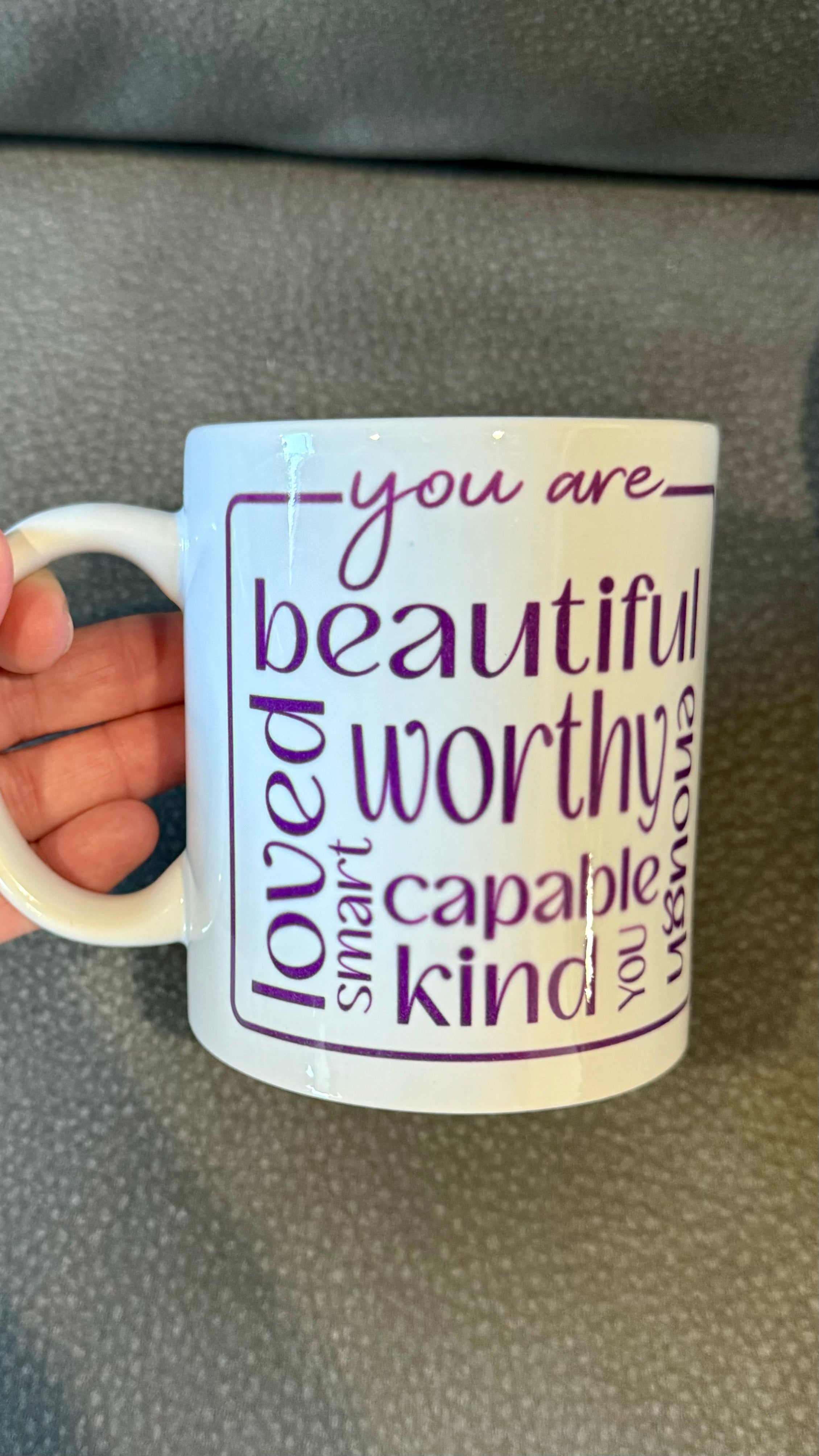 Our Affirmation Mug is a beautiful and durable ceramic mug that features an affirmation reminder that you are beautiful, loved, smart, capable, kind, worthy, and enough. The infusible ink used in the design process ensures long-lasting and vibrant colors, making this mug a perfect addition to any collection. Create a unique and stylish statement with this expertly crafted mug.